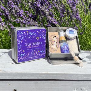 A square tin containing lavender soap, pillow spray, soap scrub and hand cream with a pretty purple label